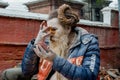 Senior man with dreadlocks and beard applying make up