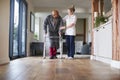 Senior Man In Dressing Gown Using Walking Frame Being Helped By Female Care Worker Royalty Free Stock Photo