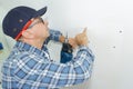 Senior man drilling holes in wall Royalty Free Stock Photo