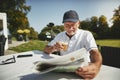 Senior man drinking coffee after playing a round of golf Royalty Free Stock Photo