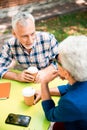 Senior man drinking coffee and talking with lady in outdoor cafe Royalty Free Stock Photo