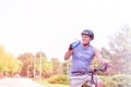 Senior man drinking water while riding bicycle in park Royalty Free Stock Photo