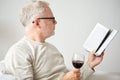 Senior man drinking wine and reading book Royalty Free Stock Photo