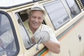 Senior Man In Driver's Seat Of Campervan Looking Through Window