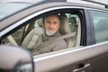 Senior man driving his modern car, going in reverse, watching ou Royalty Free Stock Photo