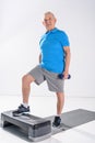 senior man with dumbbells exercising on stepper Royalty Free Stock Photo