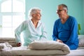 Senior man and elder woman sitting on the bed in a nursing home Royalty Free Stock Photo