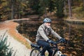 A senior man with electrobike cycling outdoors on a road in park in autumn. Royalty Free Stock Photo