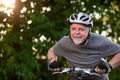 Senior man enjoying lovely bike riding or cycling in the forest during summer sunset, healthy lifestyle concept Royalty Free Stock Photo