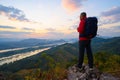 Senior man enjoys the view of cliff after hiked the hill to watch the sunrise over Mekong river in morning