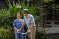 Senior man exercise walking in backyard with caregiver Royalty Free Stock Photo