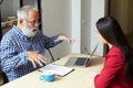 Senior man explaining something to young woman in his office Royalty Free Stock Photo