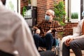 Senior man with face mask sitting in wheelchair at group therapy session Royalty Free Stock Photo