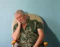 Senior man asleep in a chair.