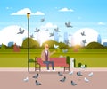 Senior man feeding flock of pigeon sitting wooden bench urban city park cityscape background horizontal flat