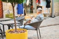 Senior man feeding kitty with ice cream at street cafe in Lviv old town, Ukraine Royalty Free Stock Photo