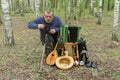 Senior man with film camera taking a photo while resting in birch forest Royalty Free Stock Photo