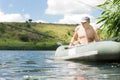 Senior man fishing from a boat on a lake Royalty Free Stock Photo