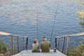 Senior man fishing with grandson, spending time near river, holding fishing rods in hands, to enjoy spending time together, Royalty Free Stock Photo