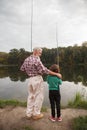 Senior man fishing with his grandson