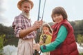 Senior man fishing on lake with his grandchildren Royalty Free Stock Photo