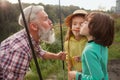 Senior man fishing on lake with his grandchildren Royalty Free Stock Photo