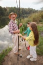 Senior man fishing on lake with his grandchildren Royalty Free Stock Photo