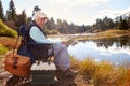 Senior man fishing in a lake, looking to camera, California Royalty Free Stock Photo