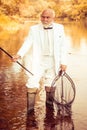 Senior man fishing and relaxing while enjoying hobby. Difference between fly fishing and regular fishing. Old mature Man Royalty Free Stock Photo