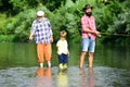 Senior man fishing with son and grandson. Summer weekend. Happy grandfather and grandson are fishing on the river. Royalty Free Stock Photo