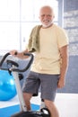 Senior man on fitness cycle smiling
