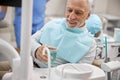 Senior man getting a cup of rinsing water for his mouth Royalty Free Stock Photo