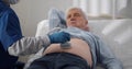 Senior man getting ultrasound examination on abdomen from doctor Royalty Free Stock Photo
