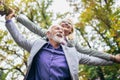 Senior man giving woman piggyback ride through park Royalty Free Stock Photo