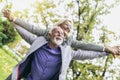 Senior man giving woman piggyback ride through park Royalty Free Stock Photo