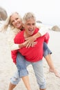 Senior Man Giving Woman Piggyback On Winter Beach