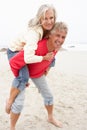 Senior Man Giving Woman Piggyback On Winter Beach