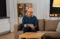 Senior man in glasses solving crossword at home Royalty Free Stock Photo