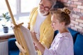 Senior man, grandfather and his granddaughter drawing, painting together Royalty Free Stock Photo