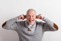 Senior man in gray woolen sweater, studio shot. Royalty Free Stock Photo