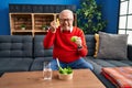 Senior man with grey hair eating salad and green apple annoyed and frustrated shouting with anger, yelling crazy with anger and Royalty Free Stock Photo