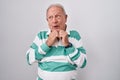 Senior man with grey hair standing over white background laughing nervous and excited with hands on chin looking to the side Royalty Free Stock Photo