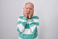 Senior man with grey hair standing over white background tired hands covering face, depression and sadness, upset and irritated