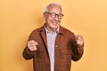 Senior man with grey hair wearing casual jacket and glasses excited for success with arms raised and eyes closed celebrating Royalty Free Stock Photo