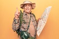 Senior man with grey hair wearing hiker backpack holding map smiling happy pointing with hand and finger to the side Royalty Free Stock Photo
