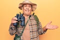 Senior man with grey hair wearing hiker bakcpack holding binoculars celebrating achievement with happy smile and winner expression Royalty Free Stock Photo