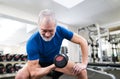 Senior man in gym working out with weights. Royalty Free Stock Photo