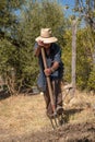 Senior man hand plowing in the field