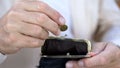 Senior man hand putting cent coin in wallet, money saving, retirement and budget