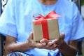 Senior man hands holding gift box with red ribbon for Christmas and New Year`s Day or Greeting season Royalty Free Stock Photo